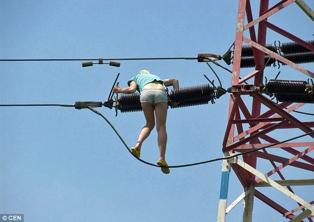 Cô gái trẻ bám vào dây cáp leo lên cột cao áp vì tưởng đó là một cây cầu.