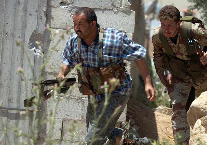 Các thành viên "Tự do cho lữ đoàn sông Assi" bỏ chạy khi quân đội Syria tấn công vào vị trí chiếm đóng của họ tại Nizareer, tỉnh Homs, gần các biên giới Lebanon ngày 12/5/2012.