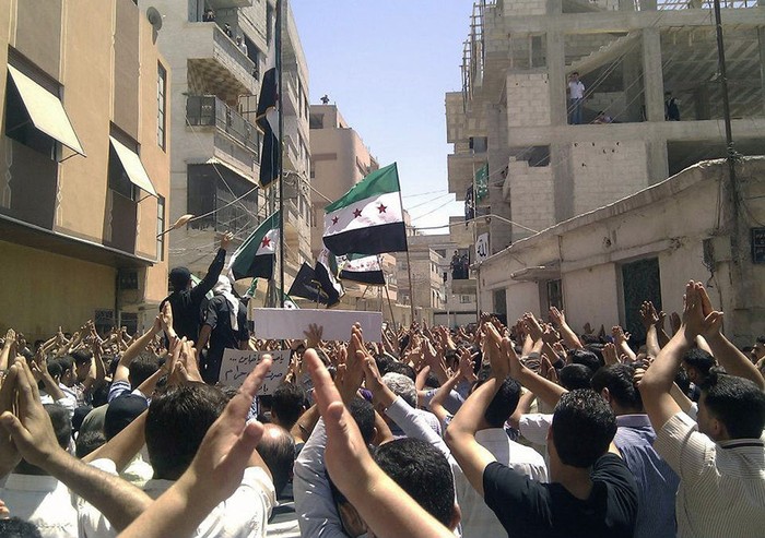 Những người biểu tình phản đối Tổng thống Syria Bashar al-Assad vỗ tay sau lễ Ngày thứ 6 Cầu Nguyện tại khu phố Erbeen, gần Damascus, vào ngày 8 tháng 6 năm 2012.