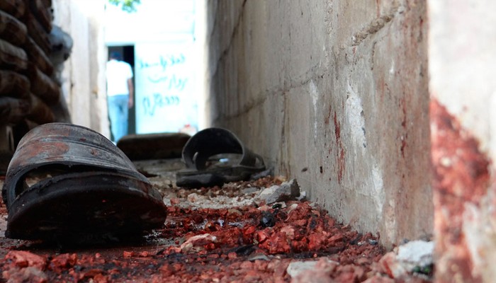 Một đôi dép nằm trên mặt đất đẫm máu sau cuộc pháo kích tại khu vực Talbisah trong thành phố Homs ngày 13/6/2012.
