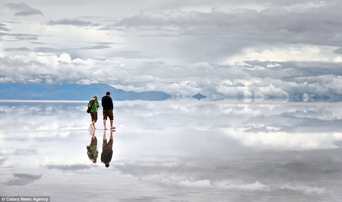Mây trời và bóng của một cặp tình nhân được phản chiếu rõ nét trên mặt hồ muối Salar de Uyuni.