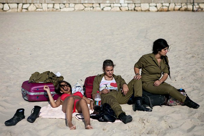 Nữ quân nhân Israel tắm nắng trên bãi biển ở Tel Aviv ngày 24/6.