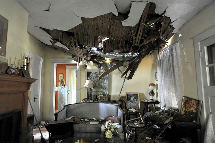 Frances Lukens nhìn đống đổ nát xuyên thủng trần phòng khách nhà mình do trận bão đêm trước tại Lynchburg, Virginia, Mỹ ngày 30/6.