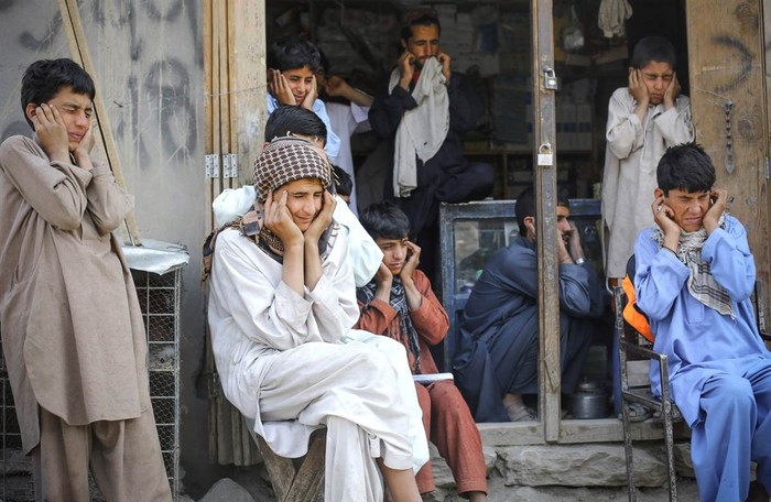Người dân bịt tai ngăn âm thanh lớn vang lại từ một trận chiến tại thung lũng Pech, Affghanistan ngày 22/6.