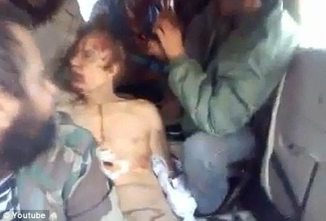 Một tay súng nổi dậy dùng đầu của Đại tá Gaddafi đã chết để giả làm búp bê nói chuyện bằng bụng.