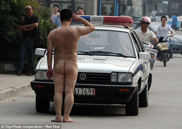 Khi cảnh sát tới hiện trường, người đàn ông loạn trí này đứng nghiêm giơ tay chào ngay phía trước xe của họ.
