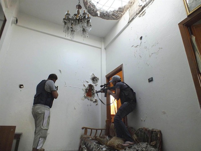 Các tay súng thuộc nhóm nổi dậy Quân đội Syria Tự do bên trong một ngôi nhà ở khu phố El Moalimin, gần Homs, Syria, ngày 14/7.