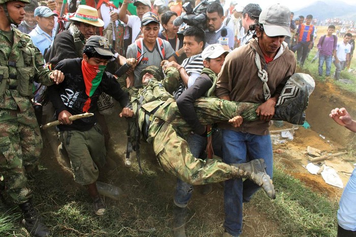 Người dân Nasa khiêng một người lính tại Toribio, Colombia ngày 17/7 trong nỗ lực xua đuổi lực lượng an ninh và phiến quân ra khỏi đất đai của họ.