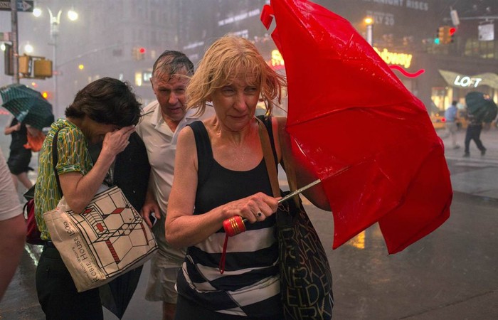 Người dân đi bộ trong mưa to gió lớn tại trung tâm Manhattan, Mỹ ngày 18/7.