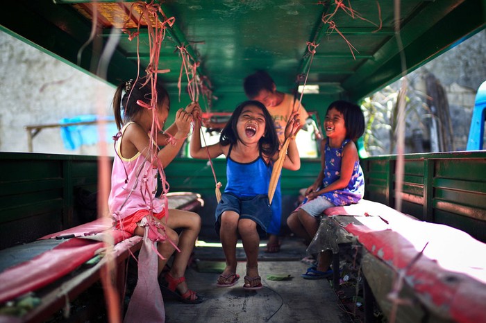 Trẻ em vui chơi trong một chiếc xe cũ tại Cebu, Philippines. Ảnh Mac Kwan.