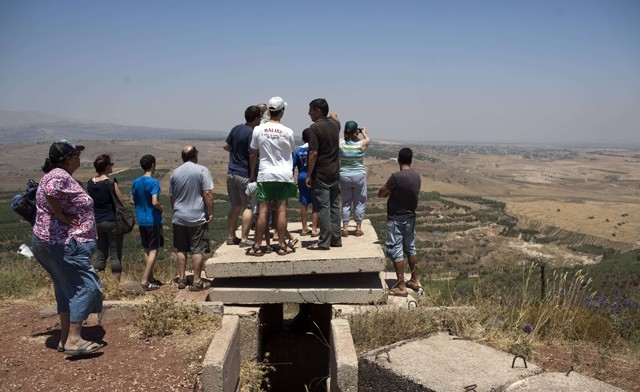 Khách du lịch Israel đang quan sát xung đột ở Syria từ làng Buqaata thuộc cao nguyên Golan, gần ngôi làng Jebata al-Khashab của Syria. (Ảnh AFP)