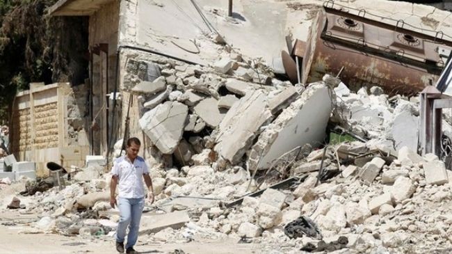 Một dân thường Syria đi bộ dọc theo con phố bị phá hủy trong xung đột tại Azaz, miền bắc Syria ngày 25 tháng 7 năm 2012.