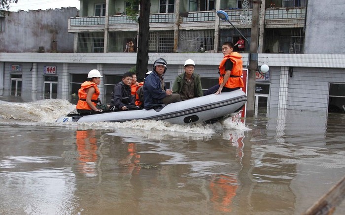 Nhân viên cứu hộ dùng thuyền cao su bơm hơi di chuyển trong thành phố Anju