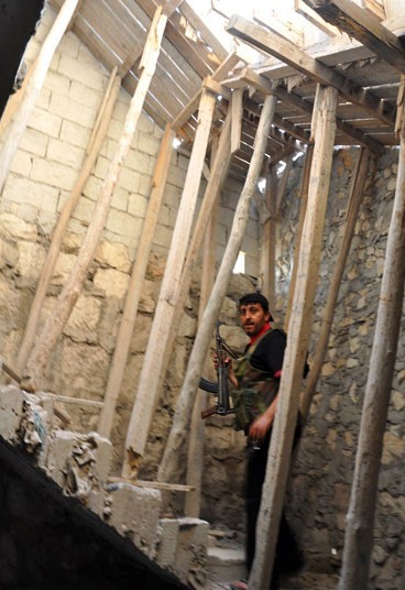 Một tay súng nổi dậy đi lên cầu thang của một tòa nhà đang xây dở tại huyện Salaheddin, Aleppo.