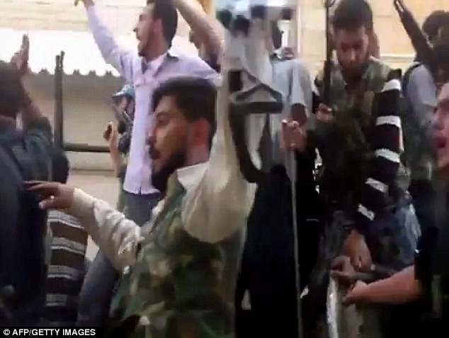 Phiến quân Syria diễu hành trên phố theo một chiếc xe tăng nhóm này tuyên bố tịch thu từ lực lượng an ninh chính phủ.