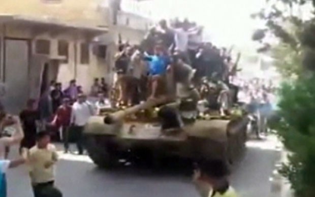 Quân nổi dậy diễu chiếc xe tăng tịch thu từ lực lượng an ninh chính phủ trên đường phố Aleppo.