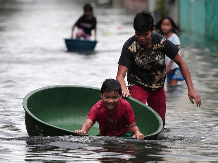 Trẻ em chơi trên một đường phố bị ngập lụt ở Obando thị xã, tỉnh Bulacan, phía bắc Manila