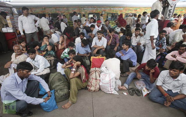 Người dân Ấn Độ ngồi trên sân ga ở New Delhi ngày 31/7 chờ các chuyến tàu hoạt động trở lại.