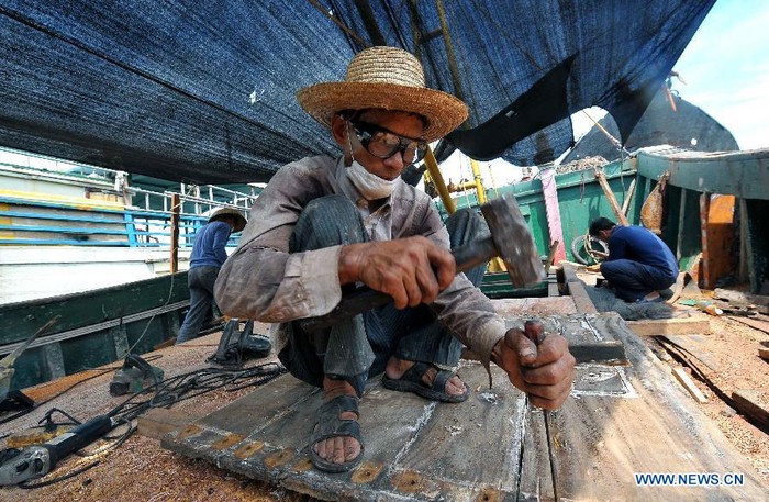 Ngư dân Trung Quốc gia cố tàu cá trước khi ra khơi ở thị trấn Đàm Môn, Quỳnh Hải tỉnh Hải Nam ngày 1/8.