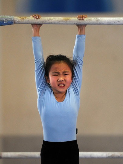 Một bé gái hít xà đơn tại một trường huấn luyện thể thao ở Hợp Phì, Trung Quốc.