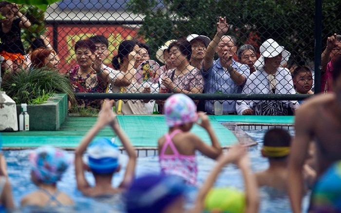 Cha mẹ xem như con cái của họ tham gia một buổi tập bơi tại Trường Thể thao Chen Jinglun.