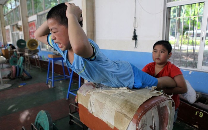 Các bé trai thuộc đội cử tạ giúp nhau tập luyện ở Hạ Môn, Phúc Kiến.