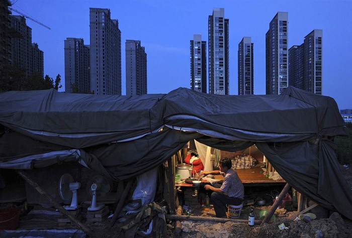 Một công nhân ăn tối trong căn nhà tạm dựng lên tại khu vực xây dựng chung cư ở Hợp Phì, Trung Quốc ngày 1/8.