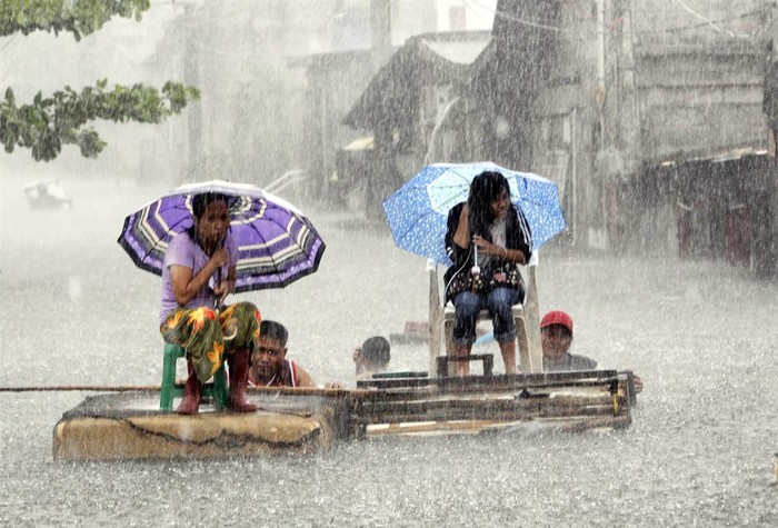 Người dân Malabon, Metro Manila, Philippines di chuyển trên đường phố ngập nước do cơn bão Saola gây ra hôm 1/8.