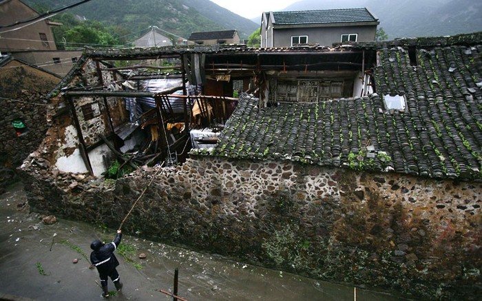Nhân viên cứu hộ kiểm tra một ngôi nhà bị bão tàn phá tại Tượng Sơn, tỉnh Chiết Giang.