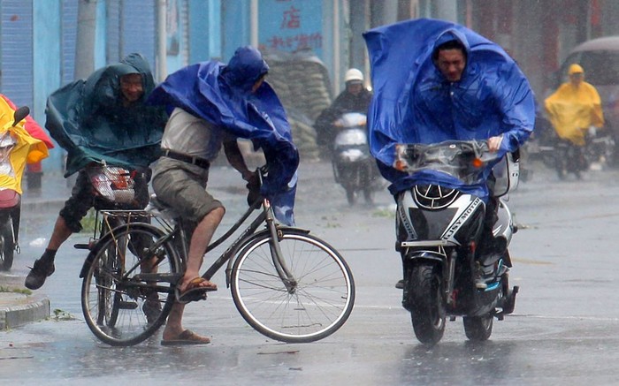 Người đi xe đạp, xe máy vật lộn với gió bão.