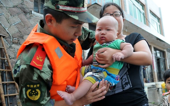 Một quân nhân giúp người dân di tản ở thành phố Ôn Châu.