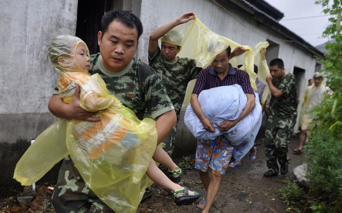 Lực lượng cứu hộ giúp đỡ người dân đi sơ tán tại Châu Sơn, tỉnh Chiết Giang.