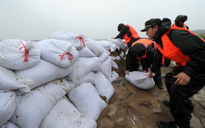 Các quân nhân dùng bao cát để củng cố bức tường chắn sóng tại vịnh Tam Môn.