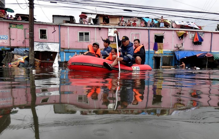 Nhân viên cứu hộ sơ tán một gia đình ra khỏi vùng ngập lụt ở Manila, Philippines ngày 8/8.