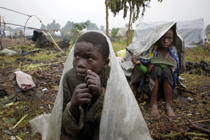 Trẻ tị nạn ngồi trong mưa chờ hàng viện trợ ở Kibati, bắc Goma, Congo.