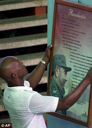 Một người đàn ông chuẩn bị treo bức chân dung của Chủ tịch Fidel Castro trong ngày mừng sinh nhật 86 của nhà cách mạng lỗi lạc.