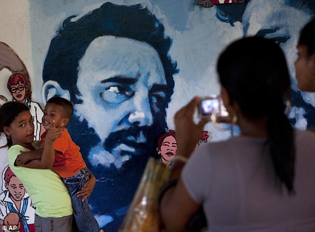 Trẻ em chụp ảnh lưu niệm bên cạnh bức chân dung Chủ tịch Fidel Castro nhân dịp sinh nhật lần thứ 86 của nhà lãnh đạo này.
