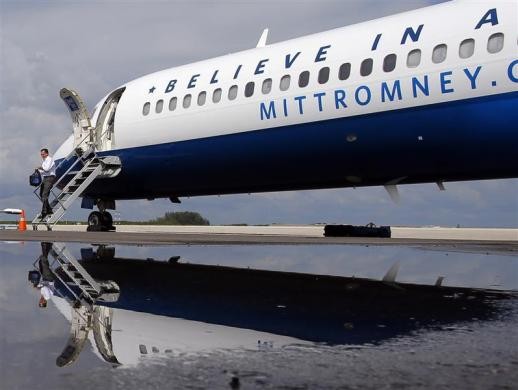 Bóng của ông Romney phản chiếu dưới vũng nước mưa khi ông rời máy bay ở sân bay tại Clearwater ngày 5/10/2012.