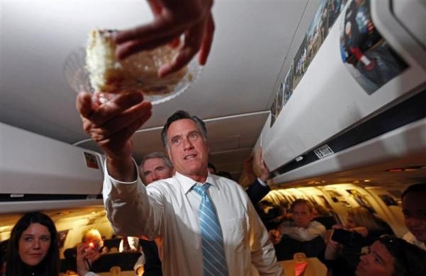 Ông Romney nhận chiếc bánh sinh nhật từ một phóng viên, người kỷ niệm sinh nhật trên máy bay phục vụ chiến dịch tranh cử của ông, trên đường tới Bedford, Massachussetts ngày 14/9/2012.