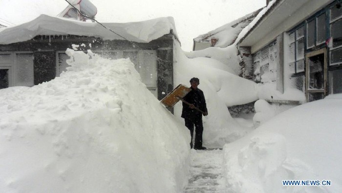 Người dân quận Diên Khánh, Bắc Kinh dọn tuyết phủ kín mái nhà và đường đi.
