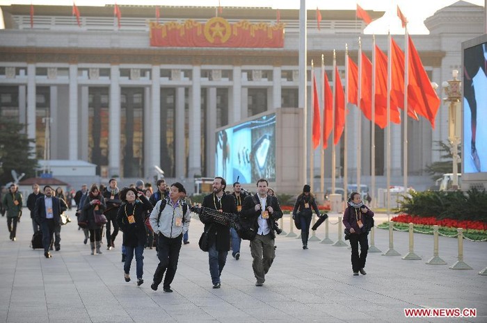 Các nhà báo tham gia tác nghiệp tại đại hội 18 đang vượt qua quảng trường Thiên An Môn hướng tới Đại lễ đường Nhân dân trước lễ khai mạc.
