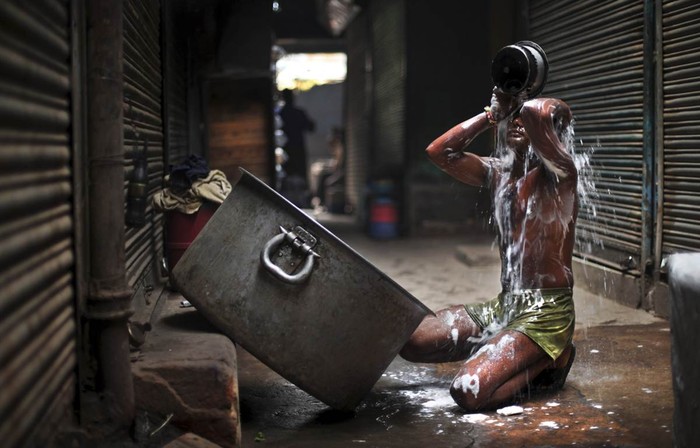 Một người Ấn Độ tắm sáng tại khu chợ ở New Delhi, Ấn Độ hôm 2/11.