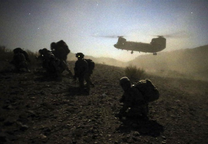 Lính Mỹ và Afghanistan ngồi xổm gần một chiếc trực thăng Chinook của quân đội Mỹ khi tham gia hoạt động quân sự gần thị trấn Walli, tỉnh Paktika, Afghanistan ngày 1/11.