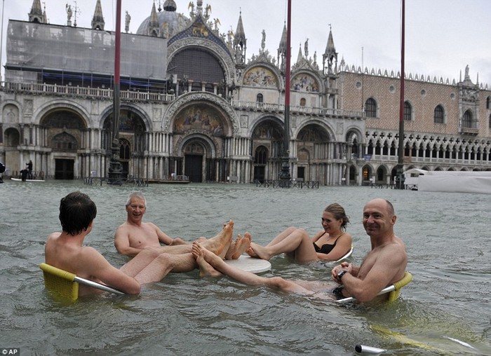 Người dân và khách du lịch tại Venice ngồi trên những chiếc ghế bị ngập nước.