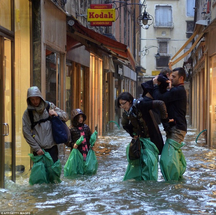Người dân Venice cố gắng di chuyển trên con phố ngập nước.