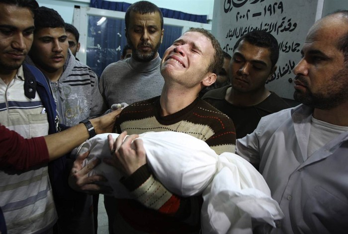 Jihad al-Masharawi, một người Palestine làm việc cho đài BBC tiếng Ả Rập ở Dải Gaza khóc khi ôm thi thể cậu con trai Omar 11 tháng tuổi đã thiệt mạng trong một vụ không kích của Israel tại thành phố Gaza ngày 14/11.