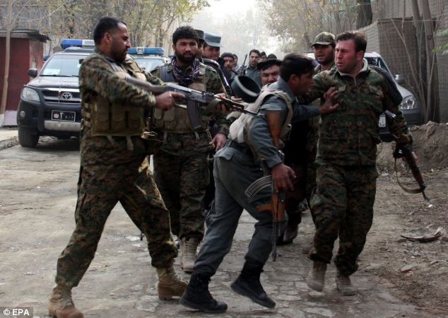 Binh sĩ Afghanistan kéo một nhân viên bảo vệ ra khỏi hiện trường vụ đánh bom tự sát.