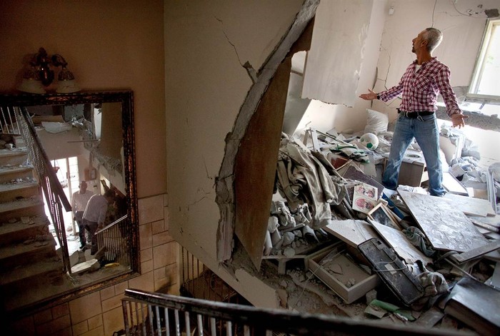 Aaron Hachmon sống tại Beersheba, Israel đứng bất lực nhìn ngôi nhà bị phá tan hoang bởi tên lửa được bắn từ Dải Gaza hôm 20/11.