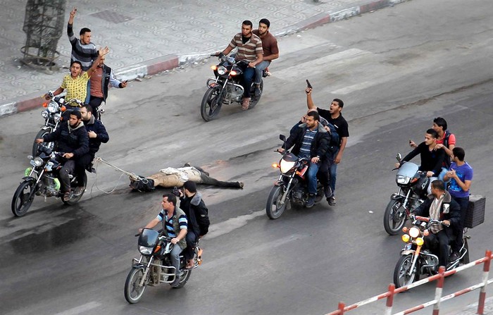 Một nhóm người Palestine kéo lê thi thể của 1 trong 6 người bị giết do tình nghi làm gián điệp cho Israel tại thành phố Gaza hôm 20/11.