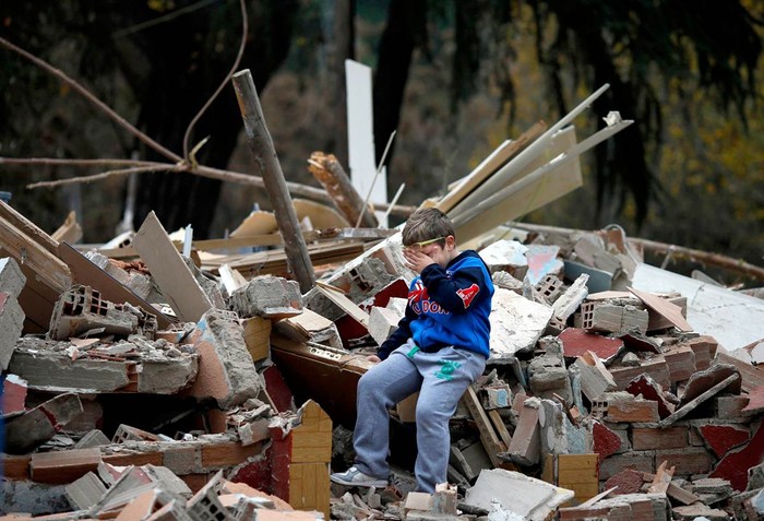 Bé Saul Gabarri Valdes, 7 tuổi, ngồi khóc trên những gì còn lại của ngôi nhà của gia đình cậu bé sau khi nó bị phá hủy ở Puerta de Hierro, ở vùng ngoại ô của Madrid hôm 20/11. 54 gia đình đã sống tại đây 50 năm nhưng từ mùa hè năm 2010 họ bị ép di dời đi nơi khác vì bị cho rằng xây nhà bất hợp pháp.